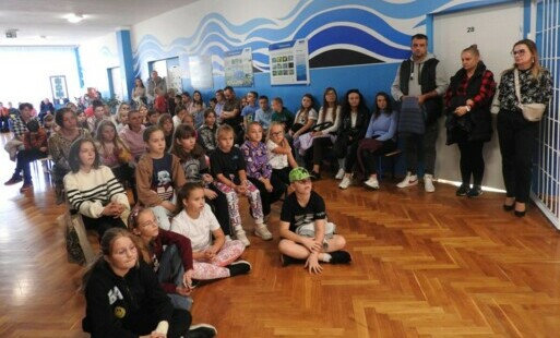 Widok na dzieci i dorosłych siedzących na sali na inauuracji